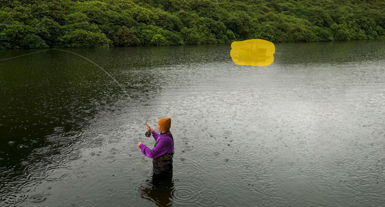 Foto de una mujer pescando con mosca en un lago, herramienta de Pixelmator Pro que borra un objeto no deseado en el fondo, resaltado en amarillo