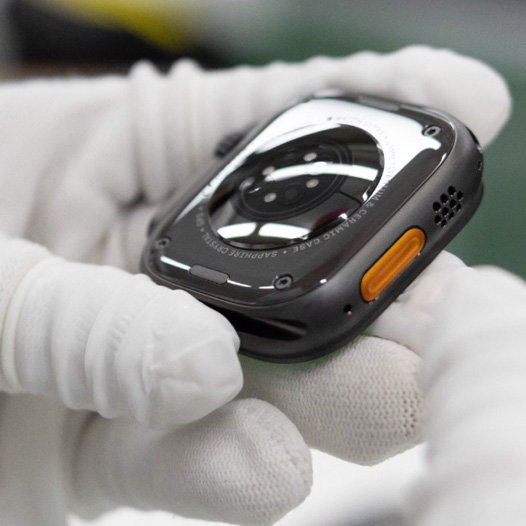 手袋をはめた手が、裏返しになったApple Watchの底部を持っている