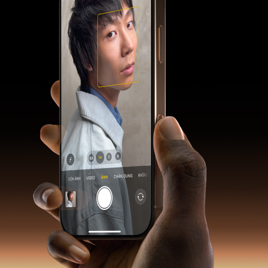 Bàn tay cầm một chiếc iPhone 16 Pro màu Titan Sa Mạc, với ngón tay cái trượt dọc theo nút Điều Khiển Camera để chọn tính năng Ảnh